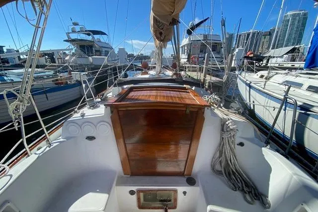Slide: The Image of 1989 Pacific Seacraft Crealock sailboat cockpit with wooden hatch, docked in a marina. - 9