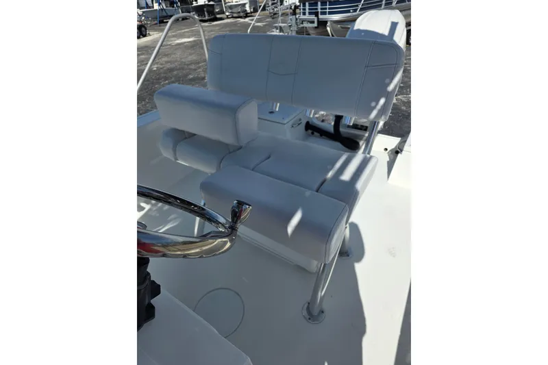 Slide: The Image of 2026 Parker 210 Coastal boat interior with white cushioned seating and steering wheel. - 11