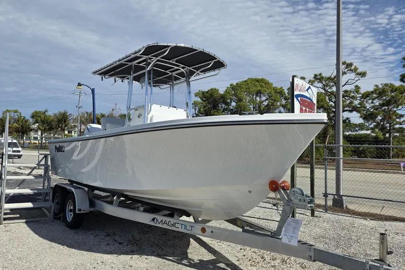 Slide: The Image of 2026 Parker 210 Coastal boat on trailer, displayed outdoors under cloudy sky. - 23