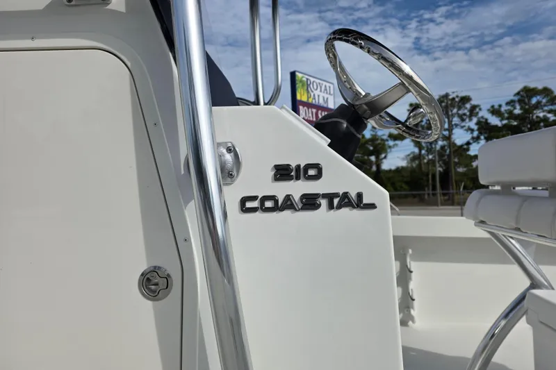 Slide: The Image of 2026 Parker 210 Coastal boat steering console with chrome details and clear sky background. - 7