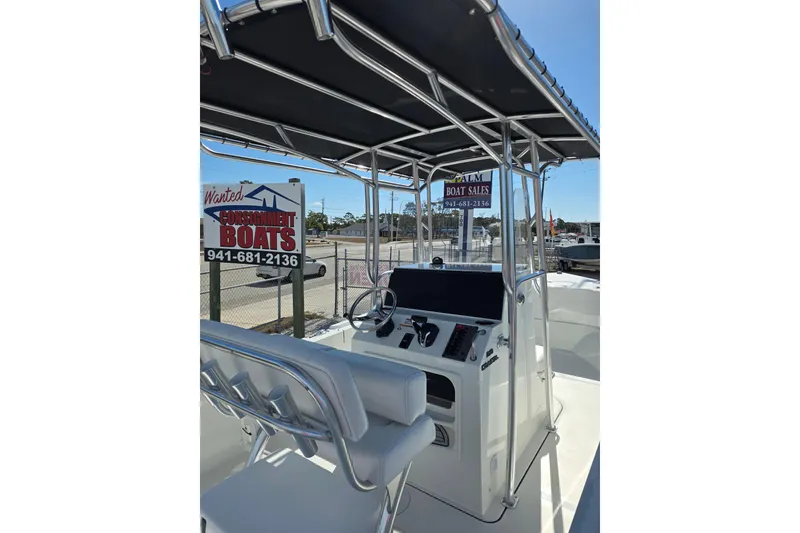 Slide: The Image of 2026 Parker 210 Coastal boat interior with helm, under a shaded canopy. - 8