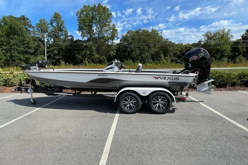 The Image of 2025 Vexus AVX1980 boat on trailer in parking lot, surrounded by trees. - 0