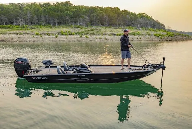 Slide: The Image of 2025 Vexus AVX1980 boat on trailer, parked outdoors under a clear blue sky. - 1