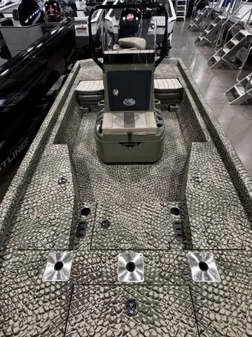 Slide: The Image of 2025 Vexus ACX2000 boat with textured deck and central console in showroom. - 9