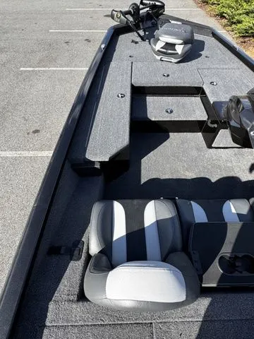 Slide: The Image of 2023 Vexus AVX181 boat interior with gray and black seating, parked on asphalt. - 7