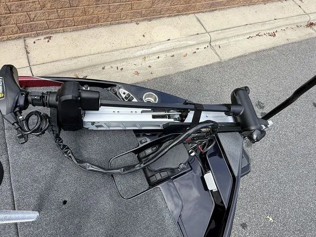 Slide: The Image of 2026 Bass Cat Lynx STS boat with advanced trolling motor on a paved surface. - 11