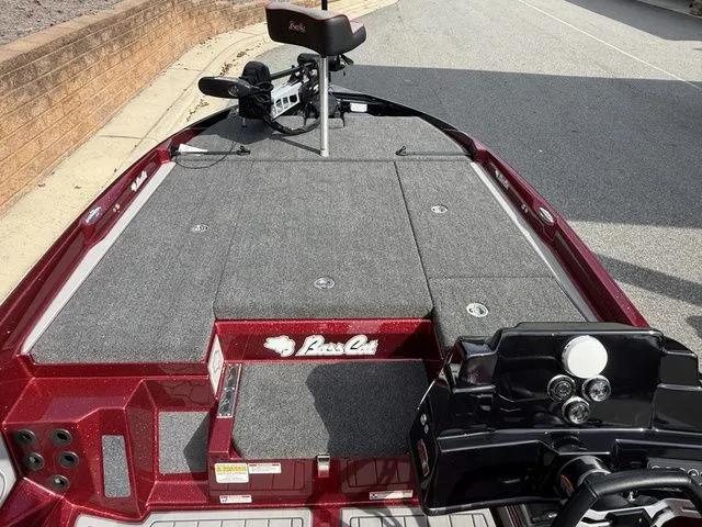 Slide: The Image of 2026 Bass Cat Lynx STS boat deck with carpeted surface and steering console. - 9