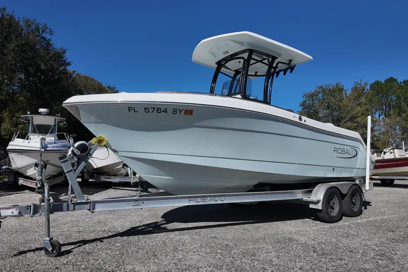 Slide: The Image of 2021 Robalo R222 Center Console boat on trailer under clear blue sky. - 5