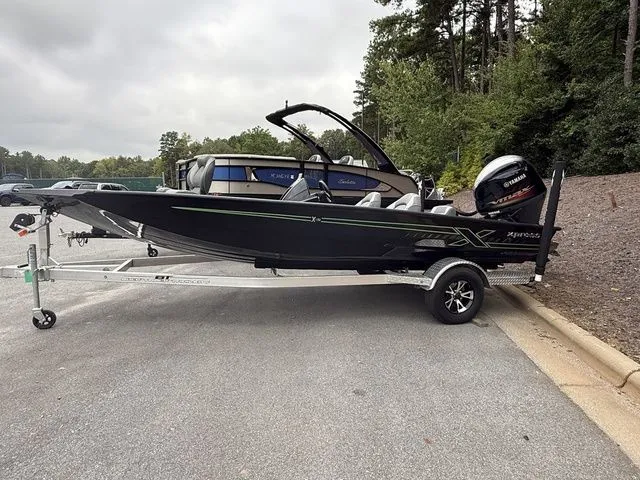 The Image of 2023 Xpress Boats X19 PRO on trailer, parked outdoors near trees. - 1