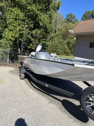 Slide: The Image of 2023 G3 Sportsman 1710 boat on trailer, parked outdoors near trees and building. - 3