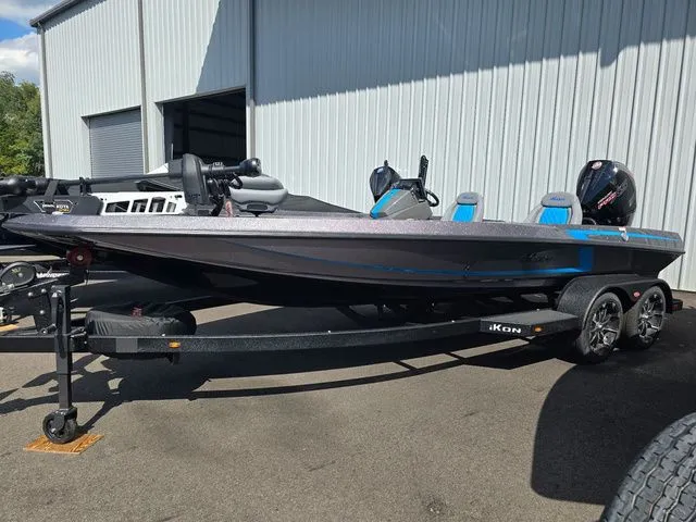 Slide: The Image of 2026 Ikon Boats LXE20 on trailer, parked outside a metal building. - 1