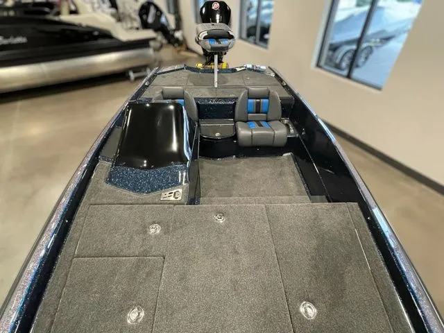 Slide: The Image of 2023 Bullet 21XRS boat interior with seating and carpeted deck in showroom. - 7