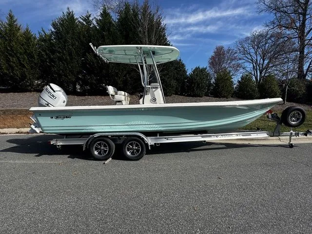 The Image of 2025 Bulls Bay 2400 boat on trailer, parked on road, surrounded by trees. - 1