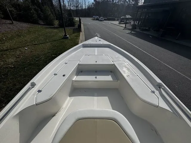 Slide: The Image of 2025 Bulls Bay 2400 boat bow view, parked on a street near greenery. - 6