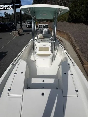 Slide: The Image of 2025 Bulls Bay 2400 boat with center console and spacious deck, parked outdoors. - 8