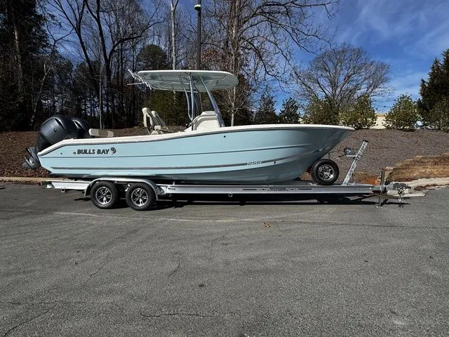 The Image of 2025 Bulls Bay 255CC boat on trailer, parked outdoors, clear sky background. - 1