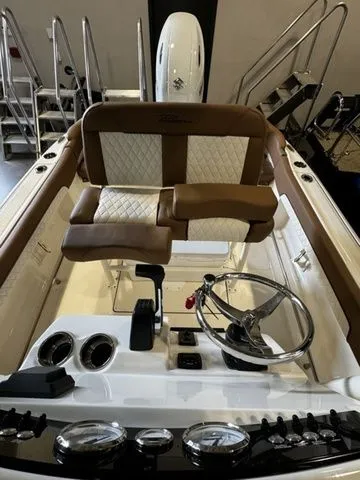 Slide: The Image of 2025 Pioneer ISLANDER 202 boat interior with brown and white seating, steering wheel, and controls. - 11