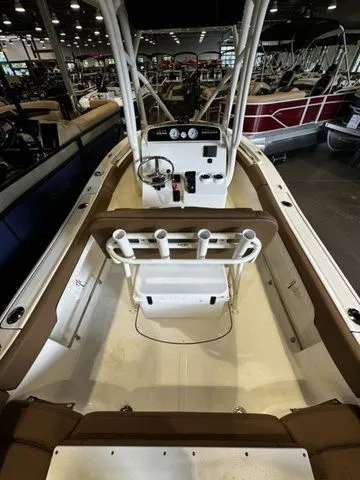 Slide: The Image of 2025 Pioneer ISLANDER 202 boat interior with steering console and rod holders in showroom. - 4