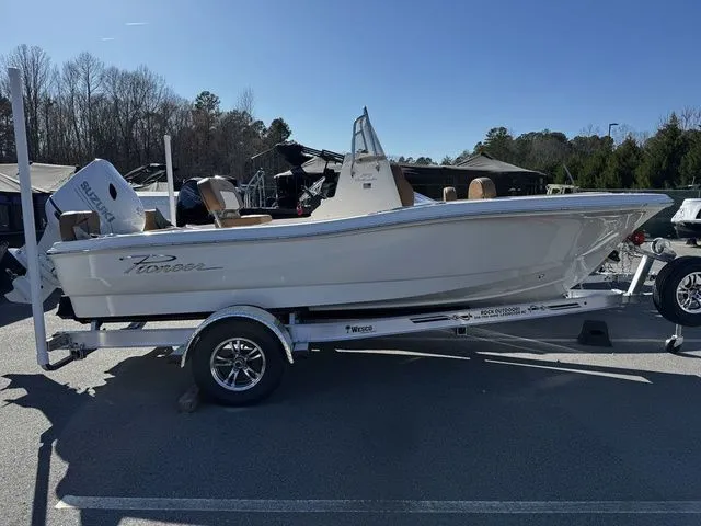 The Image of 2025 Pioneer Islander 180 boat on trailer, parked outdoors under clear blue sky. - 1