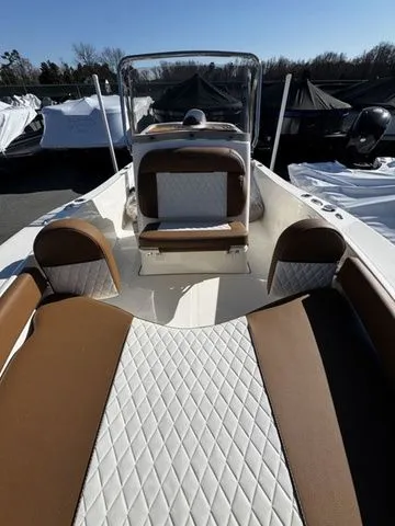 Slide: The Image of 2025 Pioneer Islander 180 boat interior with brown and white seating, outdoor setting. - 8