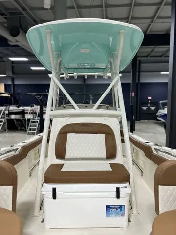Slide: The Image of 2025 Pioneer Islander 222 boat interior with seating and storage, displayed in a showroom. - 4
