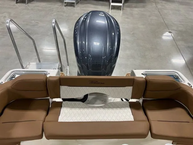 Slide: The Image of 2025 Pioneer Islander 222 boat interior with brown seating and sleek engine design. - 6