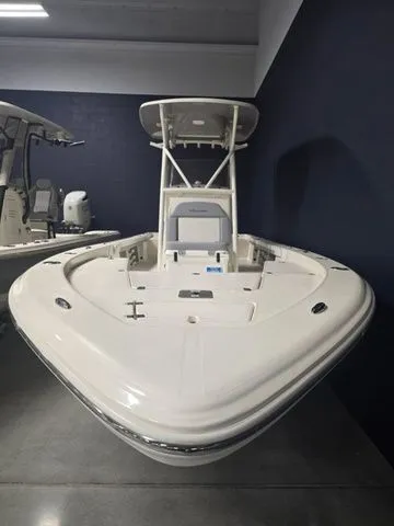 Slide: The Image of 2025 Avenger Boats AV26, sleek white design, showcased indoors. - 2