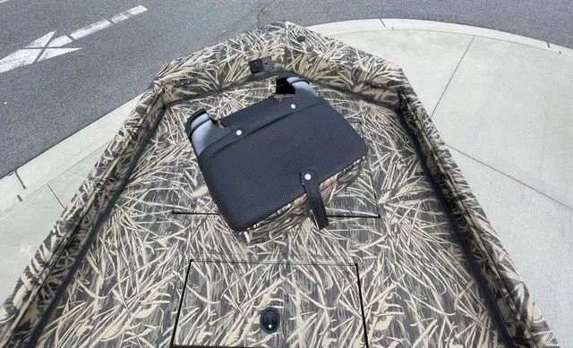 Slide: The Image of 2023 Crestliner 1860 Retriever CC boat with camouflage pattern and black seat on pavement. - 8