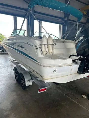Slide: The Image of 2000 Hurricane SunDeck SD 237 OB boat on trailer in garage with Mercury outboard motor. - 4