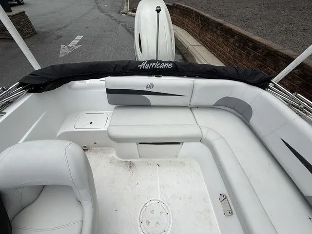 Slide: The Image of 2021 Hurricane SunDeck Sport 201 OB boat interior with white seating and storage compartments. - 12