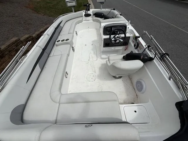 Slide: The Image of 2021 Hurricane SunDeck Sport 201 OB boat interior with white seating and steering console. - 4
