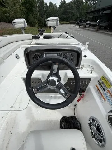 Slide: The Image of 2021 Hurricane SunDeck Sport 201 OB boat dashboard with steering wheel and controls. - 5