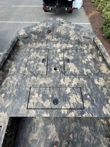 Slide: The Image of 2023 Crestliner 1760 Retriever Jon Deluxe boat with camouflage pattern and storage compartments. - 5