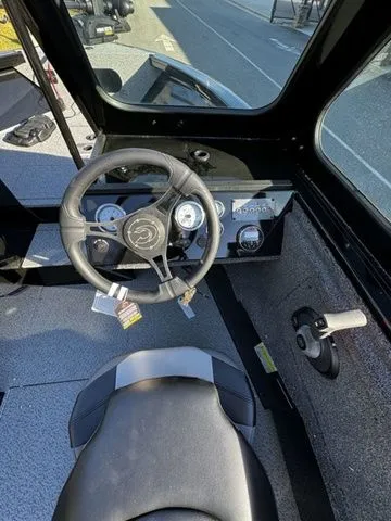 Slide: The Image of 2024 Crestliner 2050 Commander boat interior with steering wheel and dashboard controls. - 6