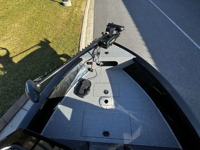 Slide: The Image of 2024 Crestliner 2050 Commander boat deck with trolling motor, parked on roadside. - 8