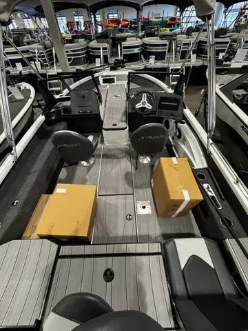 Slide: The Image of 2024 Vexus ADX190 boat interior with seating, steering console, and cardboard boxes on deck. - 3