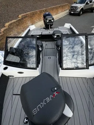 Slide: The Image of 2024 Vexus ADX180 boat with sleek design and spacious seating on a trailer. - 11