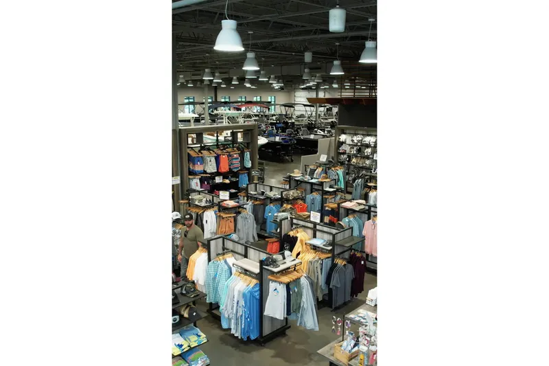 Slide: The Image of Clothing store interior with 2026 Barletta Lusso 23UCA boat in background. - 8