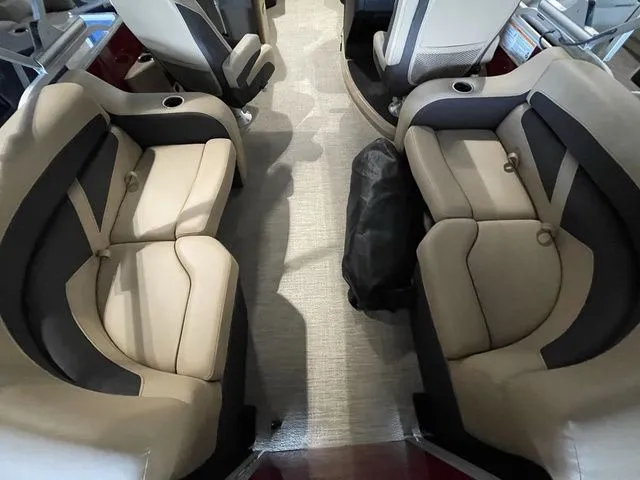 Slide: The Image of 2023 Barletta Boats C20QC interior with beige and black seating, cup holders, and carpeted flooring. - 11