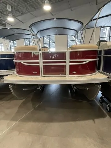 Slide: The Image of 2023 Barletta Boats C20QC pontoon in showroom, featuring a sleek red exterior. - 4