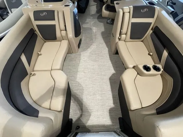 Slide: The Image of 2023 Barletta Boats C20QC interior with beige and black seating, cup holders, and carpeted flooring. - 6