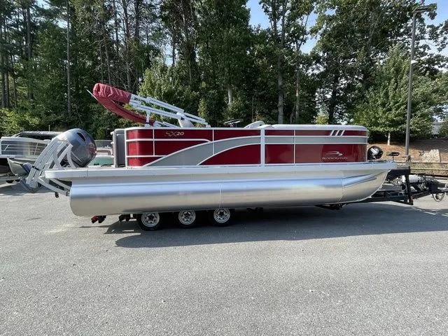 The Image of 2023 Bennington 20 SXL pontoon boat with red and silver design on a trailer. - 1