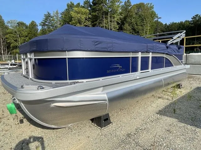 The Image of 2023 Bennington 20 SXL pontoon boat with blue cover, parked on gravel. - 1