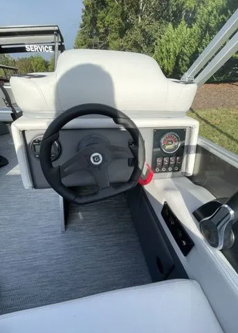 Slide: The Image of 2024 Godfrey Pontoons Mighty G 1476 F steering console with modern controls and comfortable seating. - 6