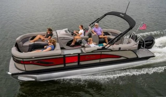 The Image of 2025 Barletta Corsa 23QCSS pontoon boat cruising with passengers on a lake. - 1