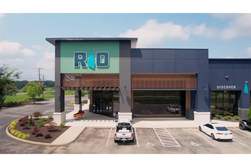 Slide: The Image of Modern building exterior with parking lot, featuring a large "RIO" sign and landscaped surroundings. - 6