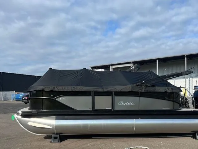 The Image of 2023 Barletta C20Q pontoon boat with cover, parked outdoors under cloudy sky. - 1