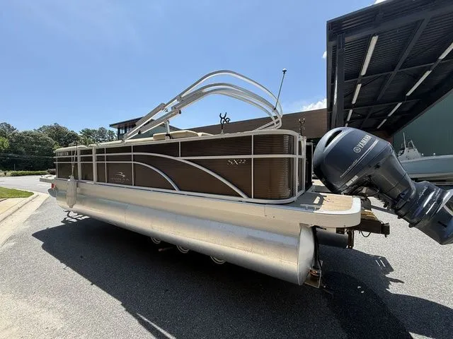 Slide: The Image of 2016 Bennington 22 SSX pontoon boat with Yamaha outboard motor, parked outdoors. - 4