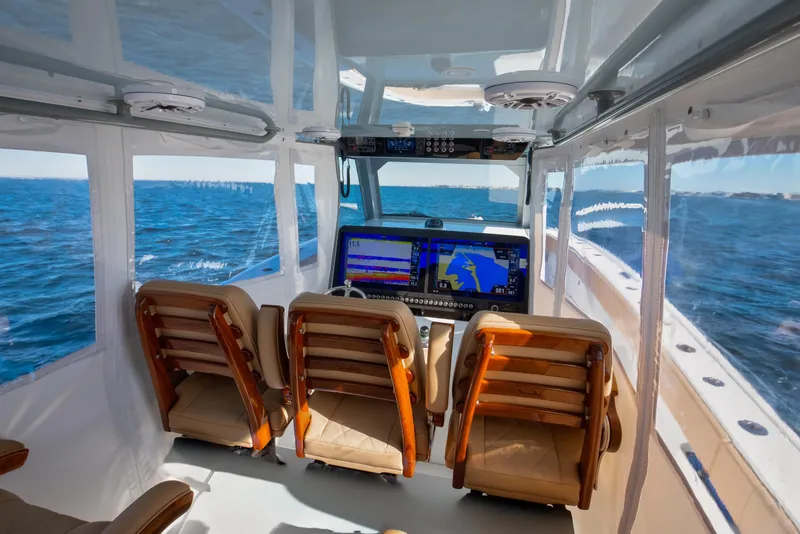 Slide: The Image of Interior of 2025 Freeman 43 Center Console boat with navigation screens and ocean view. - 10