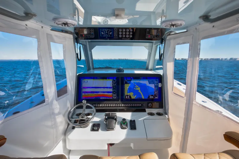 Slide: The Image of 2025 Freeman 43 Center Console boat cockpit with advanced navigation system on open water. - 11